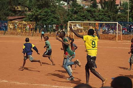 group of people playing soccer on brown field thumbnail