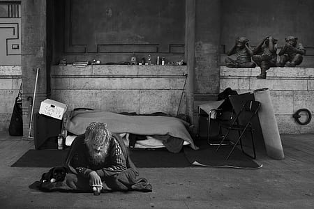 grayscale photography of man sitting on ground thumbnail