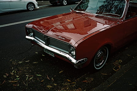 classic red car parked near side walk thumbnail
