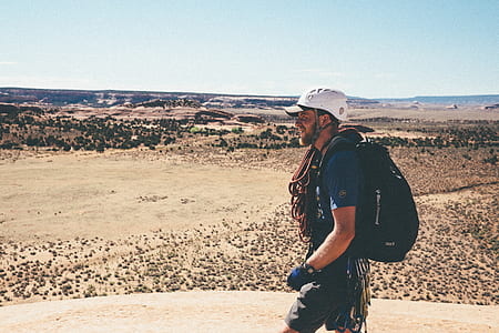 man wearing backpack and white hat thumbnail