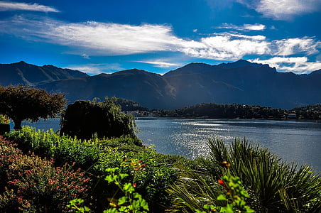 garden near body of water and mountains thumbnail