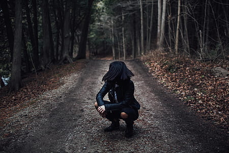 woman wearing black leather jacket and black skirt sitting on pathway thumbnail
