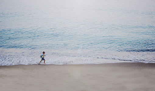 boy running beside a body of water thumbnail