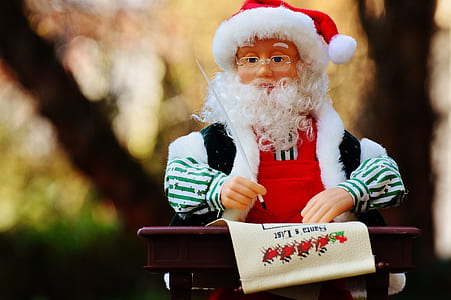 selective focus photo of Santa Claus holding pen figurine thumbnail
