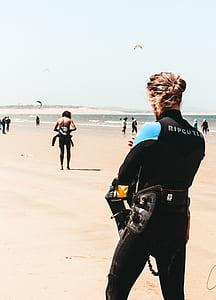 man standing while wearing wet suit near seashore during daytime thumbnail