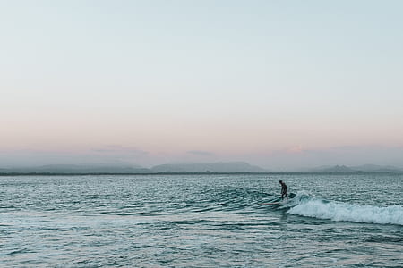 person surfboarding during daytime thumbnail