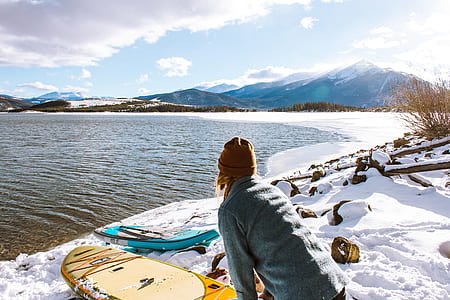 woman near two surfboards facing sea during daytime thumbnail