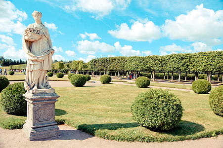 white concrete statue of woman holding flower basket thumbnail