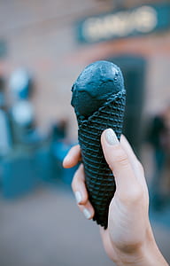 person holding charcoal-flavored ice cream and cone thumbnail