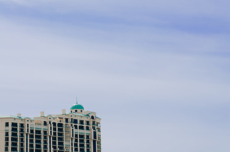 white and green concrete building under white clouds at daytime thumbnail