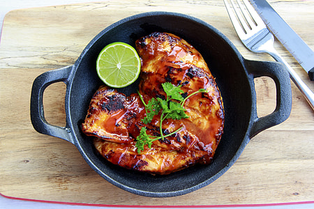 roast pork on cast iron pan topped with parsley and lime slice on side thumbnail