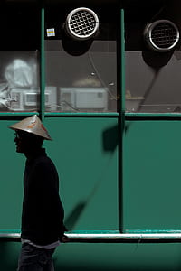 man standing near green painted wall thumbnail