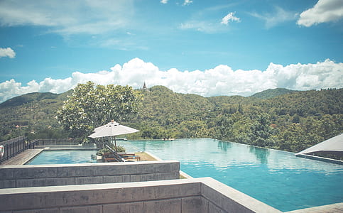 pool under cumulus clouds and blue sky thumbnail