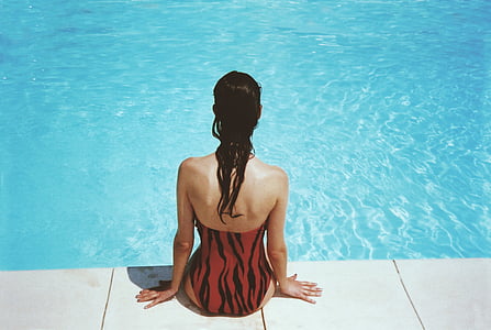 woman sitting beside pool during daytime thumbnail