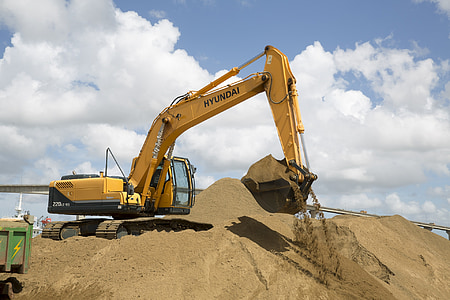 yellow Hyundai backhoe on sand thumbnail