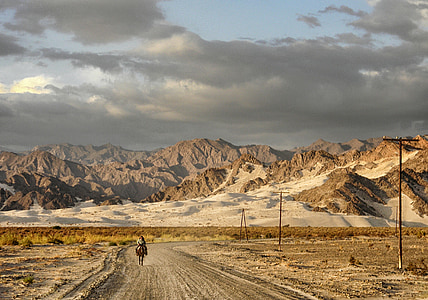 man riding horse in middle of desert during daytime thumbnail