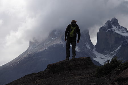 man standing while looking at mountain thumbnail