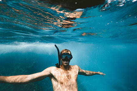 underwater photography of man wearing snorkel goggles thumbnail
