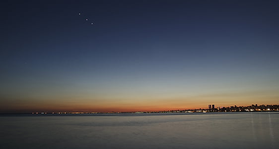 ocean near houses and buildings during sunset thumbnail