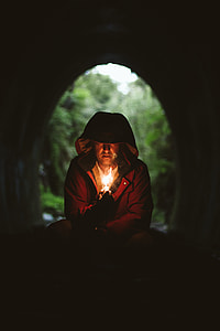 person holding candle stick inside of cave thumbnail