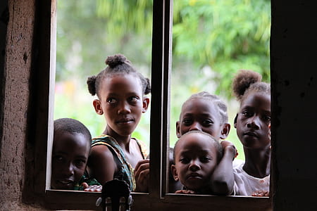 closeup photography of children near window during daytime thumbnail