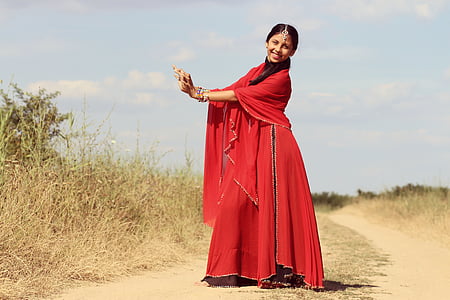 woman wearing red tradition dress nearby brown grass thumbnail