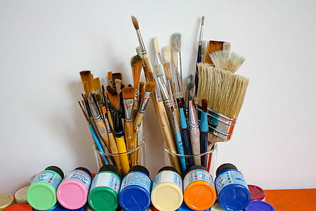 assorted paint brushes in glass cup thumbnail