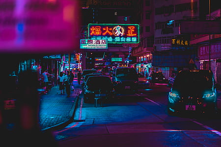 cars parked near sidewalk with people walking at night thumbnail