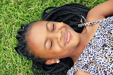 girl in white and black leopard print top lying on green grass field thumbnail