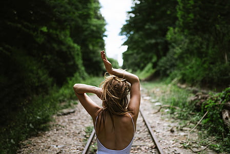 woman in the middle of rail road lifting her hands up thumbnail