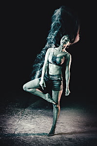 grayscale photo of woman in sports bra and shorts raising right foot thumbnail