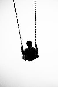 silhouette photo of boy riding swing thumbnail