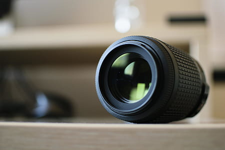 black camera zoom lens on brown wooden table thumbnail