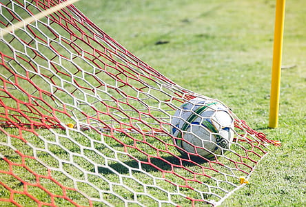 red and white net on white and green soccer ball thumbnail
