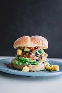 closeup photography of burger sandwich with vegetables on plate thumbnail