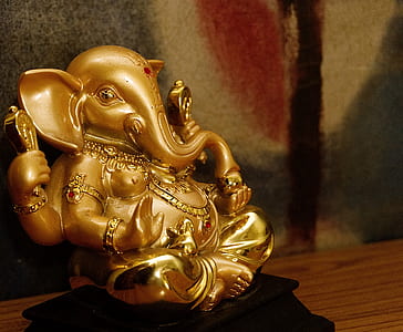 selective focus photography of gold Lord Ganesha figurine thumbnail