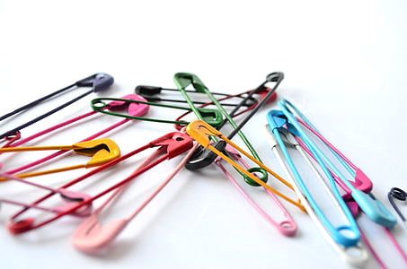 multicolored safety pin lot on white surface thumbnail