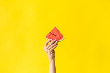 Slice of Watermelon in Woman Hand on Bright Yellow Background thumbnail