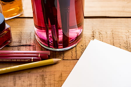 four pencils beside glass bottle thumbnail