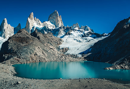lake surrounded by glacier mountains under blue sky at daytime thumbnail
