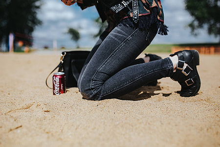 Young woman wearing a leather jacket and sunglasses on the beach thumbnail