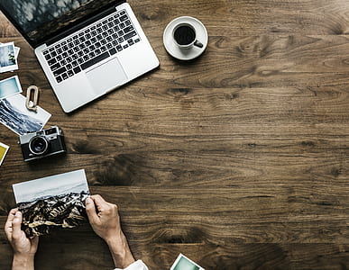 person sitting near laptop computer and cup filled with coffee thumbnail