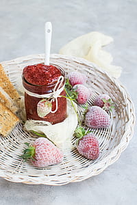 strawberry and strawberry jam bottle on round beige wicker plate thumbnail