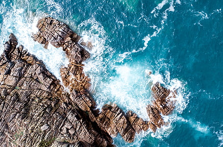aerial photography of sea waves crashing rocks at daytime thumbnail
