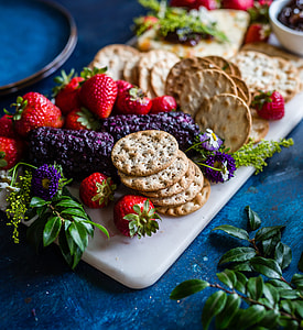 cookies, strawberries, and purple fruits on chopping board thumbnail