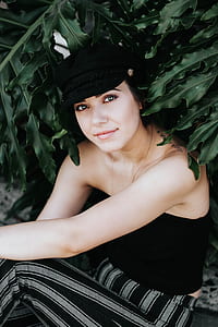 woman wearing black strapless shirt under green leafed plant thumbnail