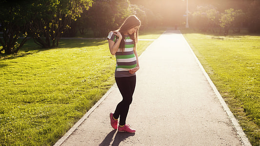 photo of woman in black, white, and green striped shirt and black pants thumbnail