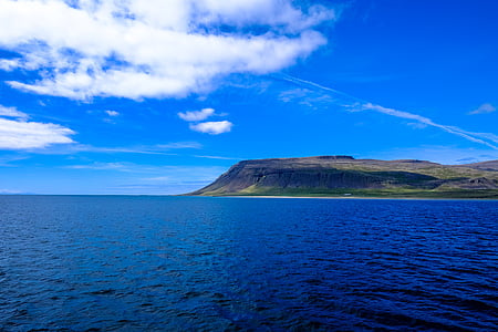 calm body of water under blue sky and white clouds during daytime thumbnail