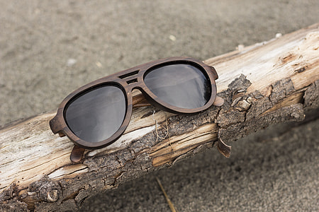 brown framed sunglasses on tree branch during daytime thumbnail