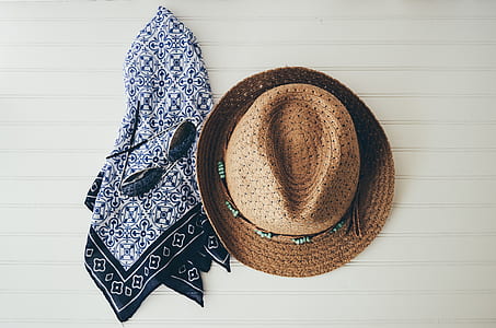 brown fedora hat beside white and black towel thumbnail